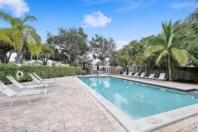 community pool featuring fence and a patio area