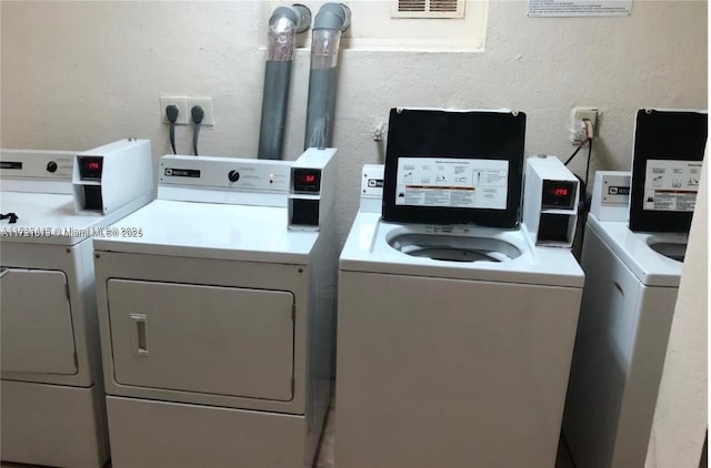 shared laundry area with washing machine and dryer and a textured wall