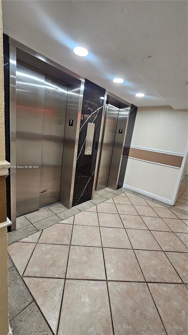 corridor featuring recessed lighting, elevator, and light tile patterned floors