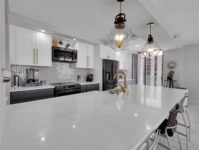 kitchen with a breakfast bar, light stone counters, appliances with stainless steel finishes, decorative backsplash, and white cabinets