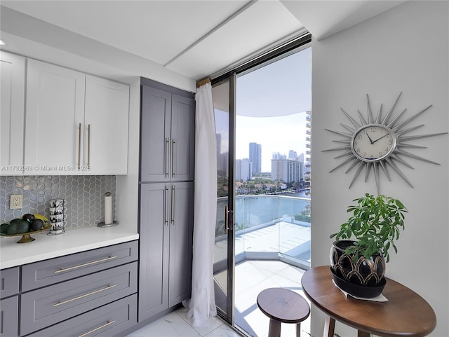 kitchen with white cabinetry, floor to ceiling windows, gray cabinetry, and backsplash