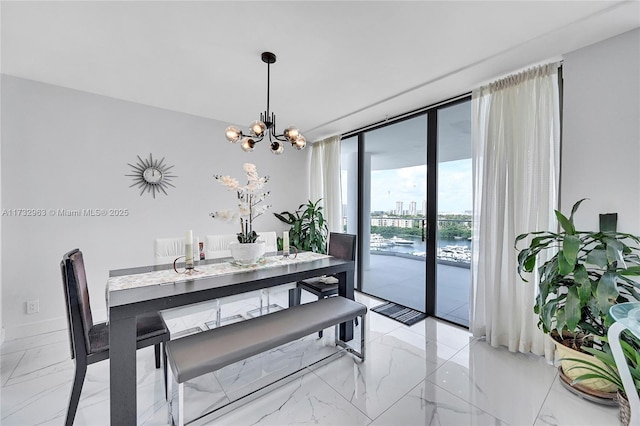 dining space with an inviting chandelier, expansive windows, and a water view