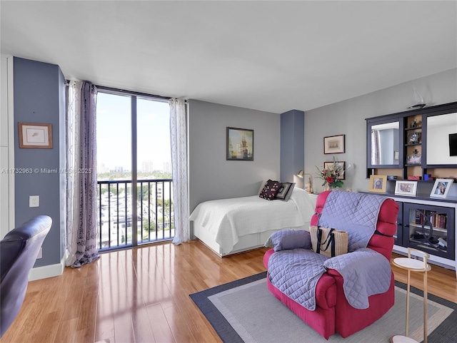 bedroom with access to outside and light wood-type flooring