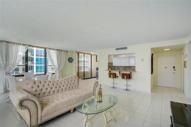 tiled living room featuring a textured ceiling