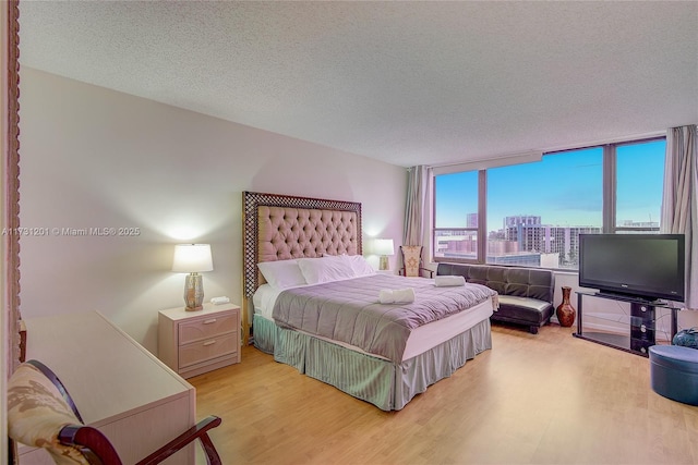 bedroom with a textured ceiling and light hardwood / wood-style floors