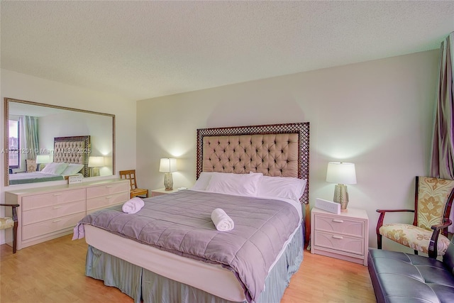 bedroom featuring light hardwood / wood-style flooring and a textured ceiling