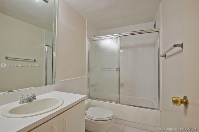 full bathroom with tile patterned flooring, vanity, shower / bath combination with glass door, and toilet