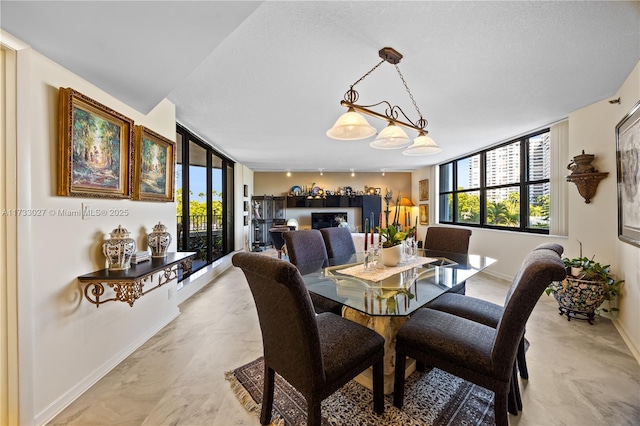 dining area featuring a wealth of natural light, marble finish floor, rail lighting, and baseboards