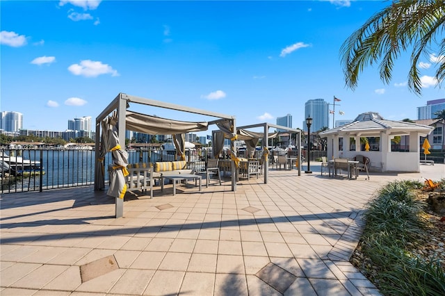 view of patio / terrace with a view of city, a gazebo, and a water view