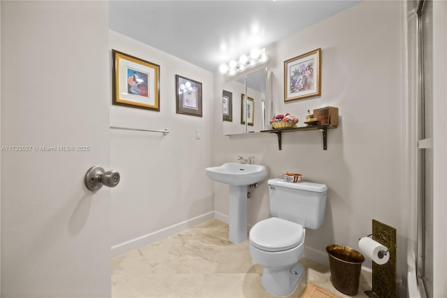 bathroom featuring a sink, toilet, and baseboards