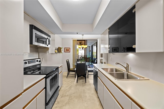 300 Three Islands Blvd Unit 102, Hallandale Beach, FL 33009 - kitchen with appliances with stainless steel finishes, a sink, a chandelier, light countertops, and a raised ceiling