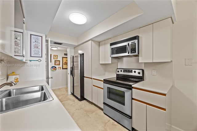 300 Three Islands Blvd Unit 102, Hallandale Beach, FL 33009 - kitchen featuring stainless steel appliances, a sink, light countertops, and white cabinetry