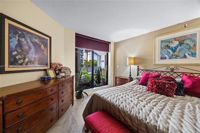 bedroom featuring access to exterior, marble finish floor, and a textured ceiling