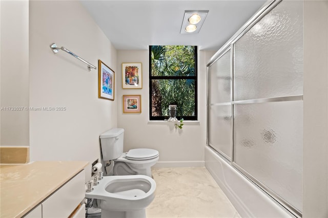 full bath with bath / shower combo with glass door, toilet, a bidet, vanity, and baseboards