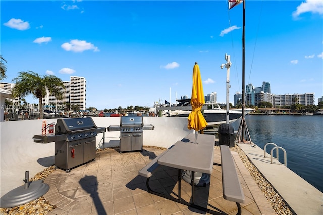 view of dock featuring a water view, a view of city, and a patio