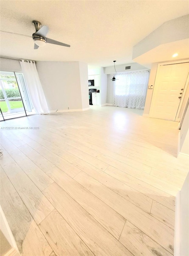 spare room with hardwood / wood-style floors, a textured ceiling, and ceiling fan