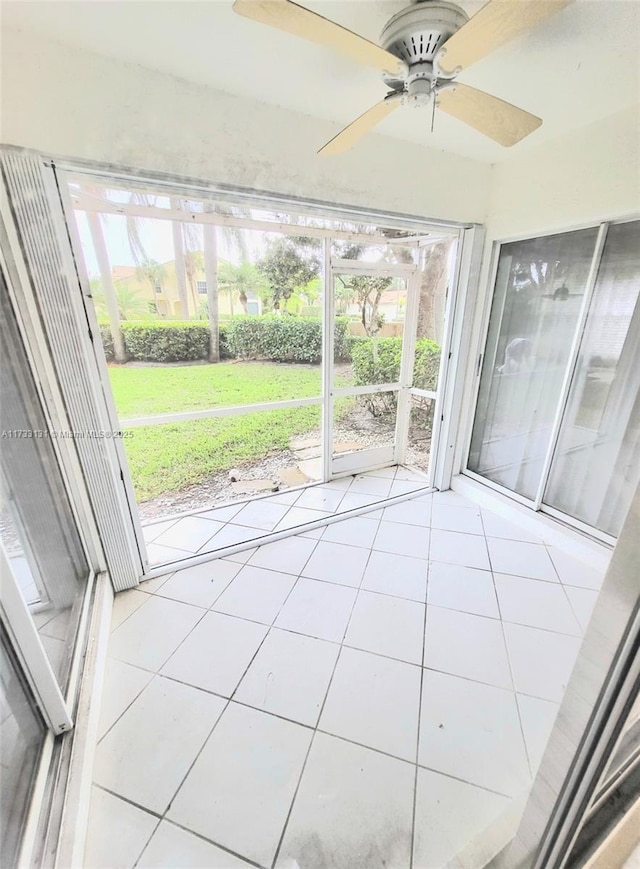 unfurnished sunroom with ceiling fan