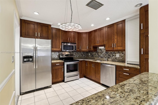 kitchen featuring pendant lighting, sink, backsplash, light stone counters, and stainless steel appliances