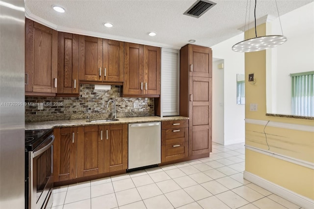 kitchen featuring appliances with stainless steel finishes, sink, light stone counters, and decorative light fixtures