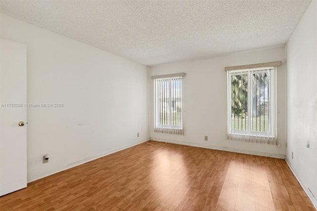 empty room with hardwood / wood-style floors and a textured ceiling