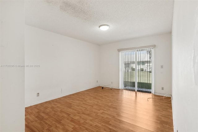 empty room featuring wood-type flooring and a textured ceiling