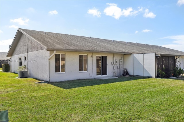 rear view of property with central AC unit and a lawn