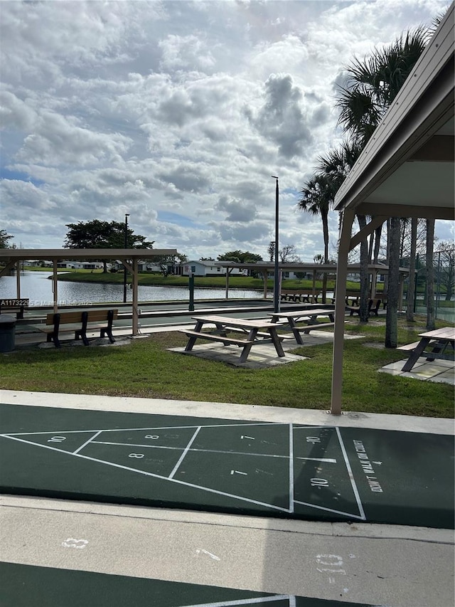 view of community with a water view and a lawn