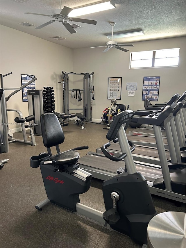 gym featuring ceiling fan and a textured ceiling