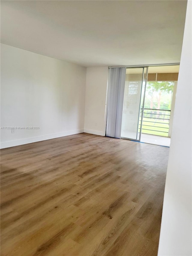 unfurnished room featuring expansive windows and wood-type flooring