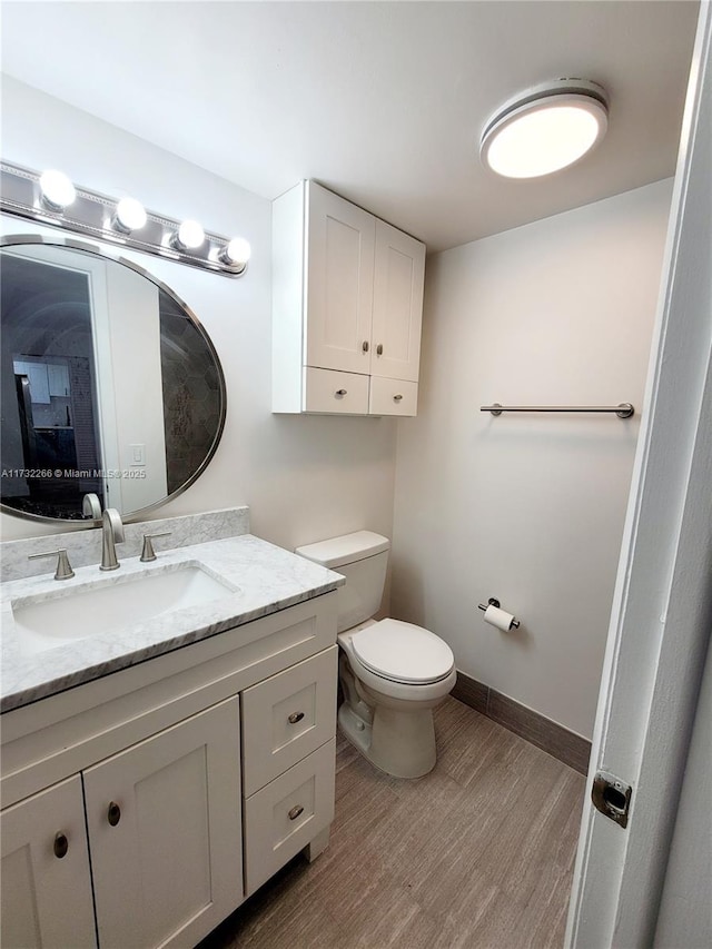 bathroom featuring vanity, hardwood / wood-style flooring, and toilet