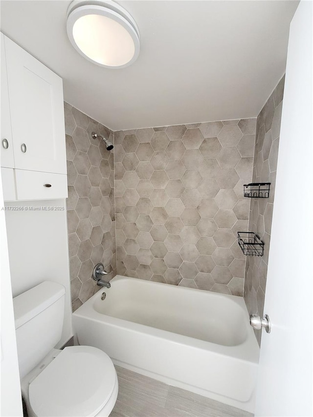 bathroom featuring shower / washtub combination and toilet