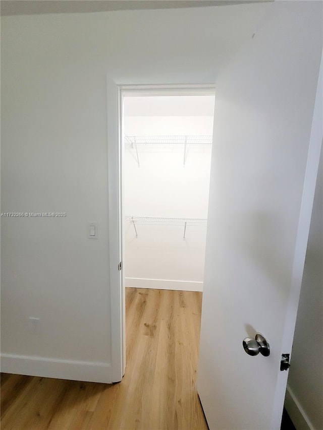 walk in closet with hardwood / wood-style flooring