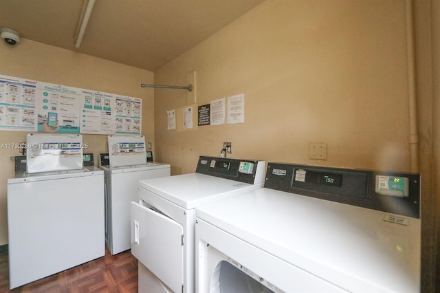 clothes washing area featuring separate washer and dryer and dark parquet floors