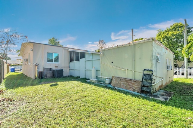 rear view of house with a lawn and central air condition unit