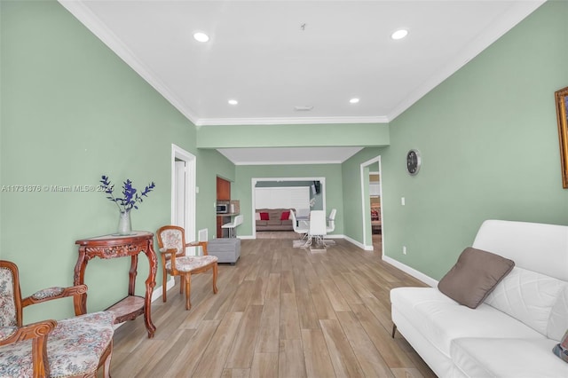 sitting room with ornamental molding and light hardwood / wood-style flooring