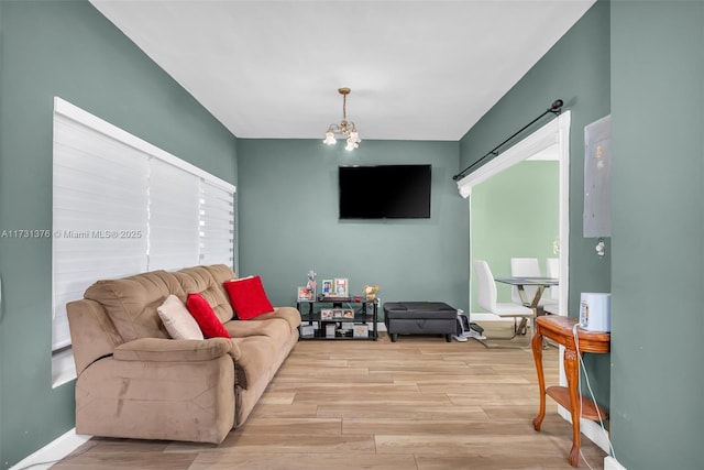 living room featuring plenty of natural light, a chandelier, and light wood-type flooring