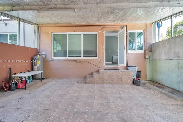 entrance to property with water heater and a patio area