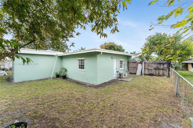 back of property featuring a yard