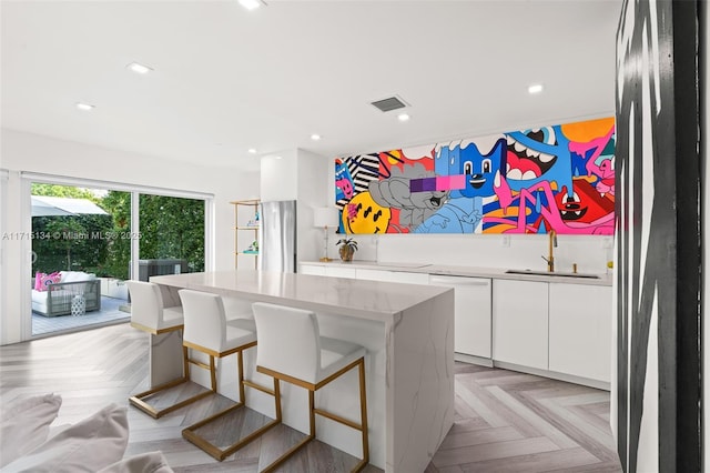 kitchen with white cabinets, dishwasher, sink, and light parquet flooring