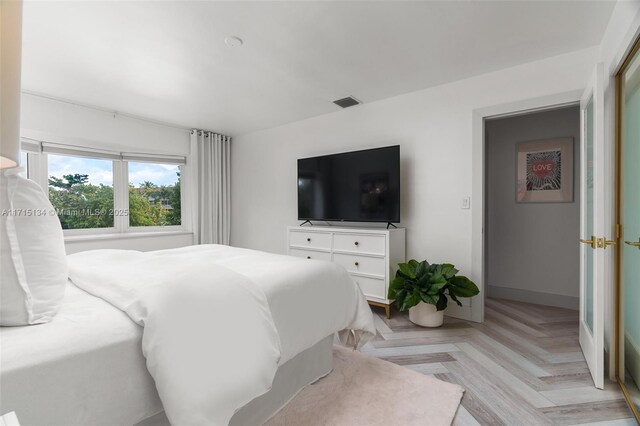 bedroom with light parquet flooring
