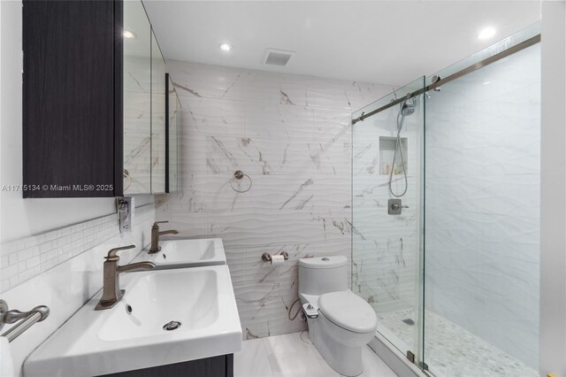 bathroom with tile walls, vanity, a shower with shower door, and toilet