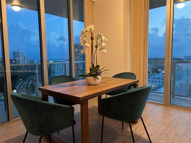 dining area featuring hardwood / wood-style flooring, plenty of natural light, and expansive windows