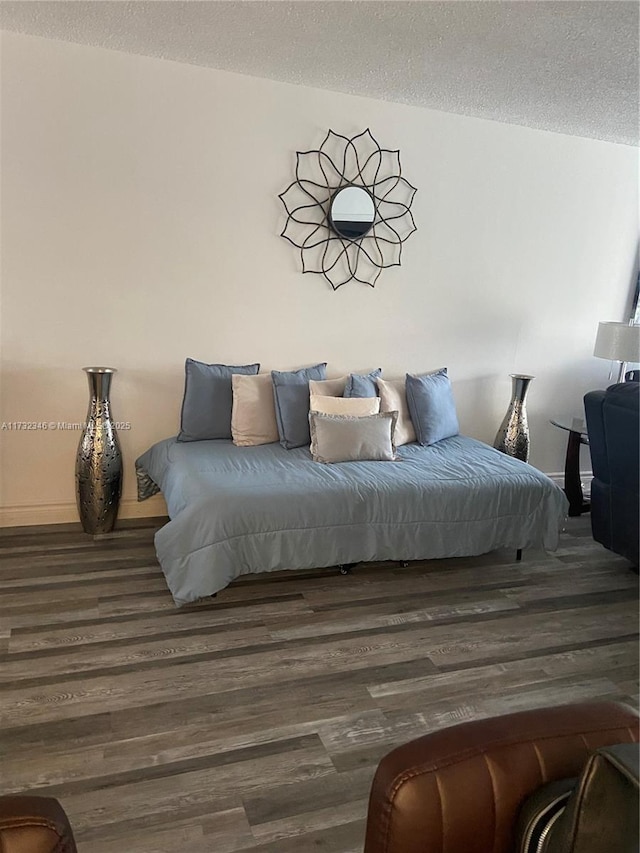 bedroom featuring dark wood-type flooring and a textured ceiling