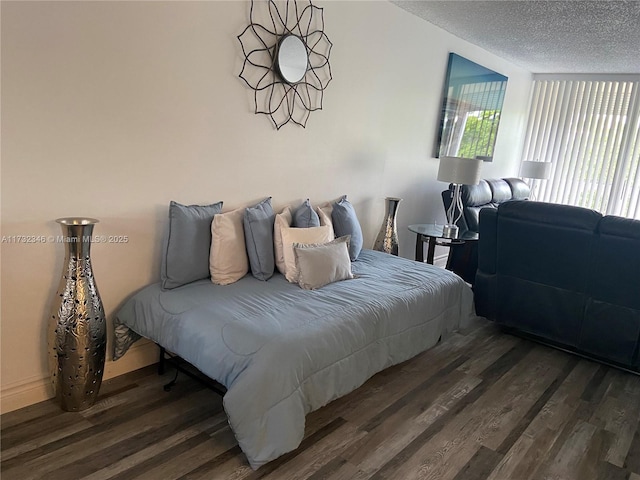 bedroom featuring dark hardwood / wood-style flooring and a textured ceiling