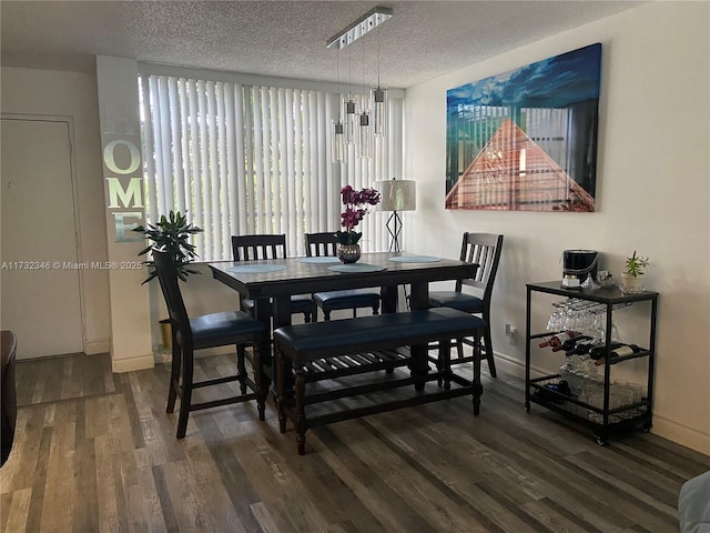 dining area with dark hardwood / wood-style floors and a textured ceiling