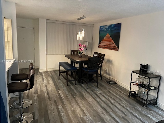 dining room featuring wood-type flooring and a textured ceiling