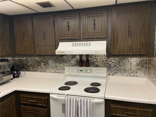 kitchen featuring built in desk, dark brown cabinets, exhaust hood, and electric range