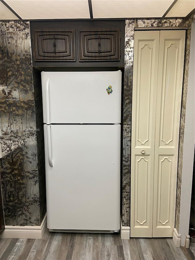 kitchen with dark brown cabinetry, hardwood / wood-style floors, and white fridge