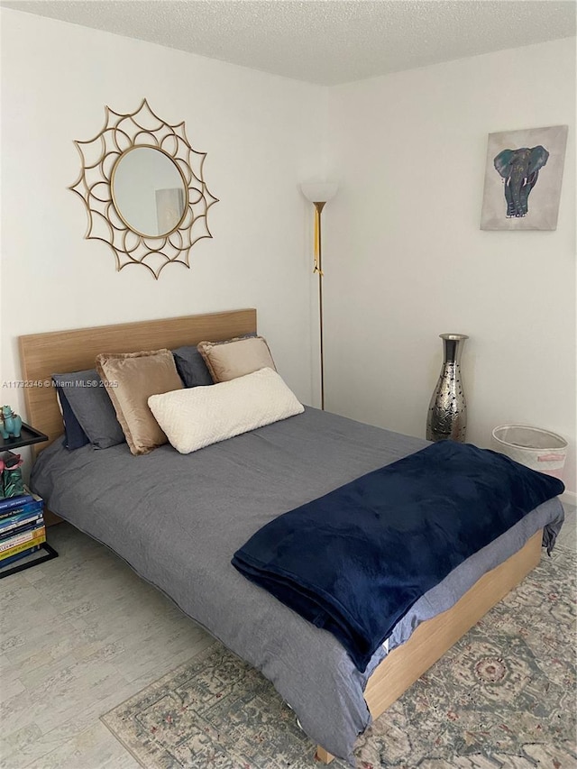 bedroom with hardwood / wood-style flooring and a textured ceiling