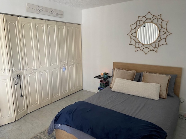 bedroom featuring a closet, a textured ceiling, and light hardwood / wood-style flooring